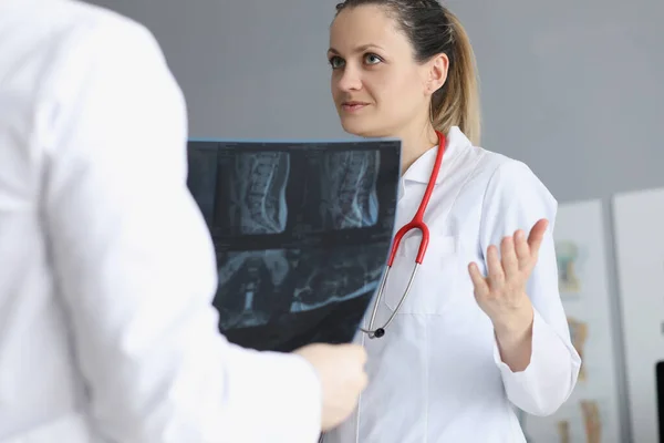 Médica deliberada com colega sobre a história médica dos pacientes — Fotografia de Stock