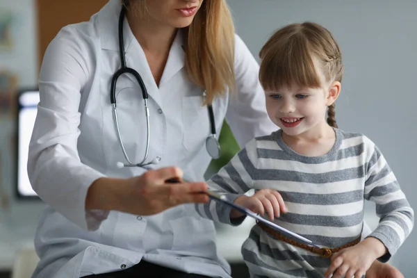 소아과 의사인 여자는 어린이 의주 의를 산 만하게 하여 진단을내리려고 노력한다 — 스톡 사진