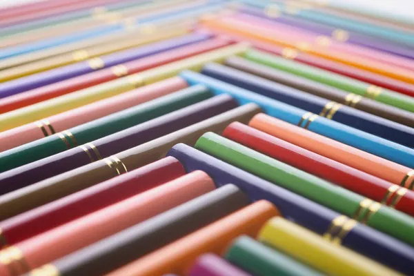 Stack med färgade pennor i kreativ ordning med gyllene design på — Stockfoto