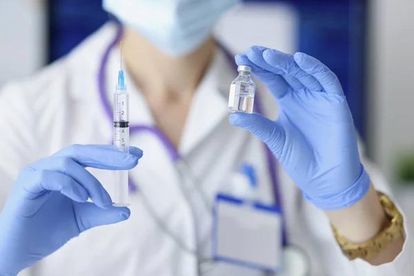 Läkare som håller sprutan och flaskan med vaccin mot coronavirus — Stockfoto