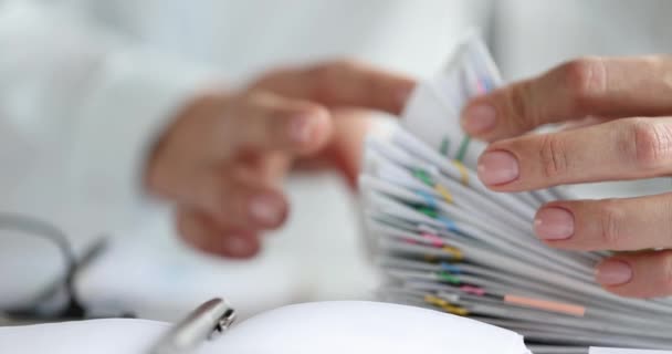 Vrouw sorteren papieren documenten met kleurrijke paperclips closeup 4k film slow motion — Stockvideo