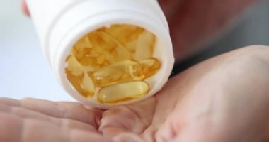 Kadın eline bir sürü jelatin kapsülü döküyor. 4K film yavaş çekim.