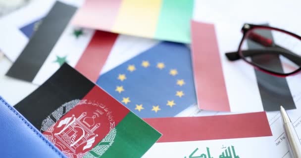 Флаги африканских и азиатских стран, лежащие вокруг флага ЕС крупным планом 4k фильм замедленной съемки — стоковое видео