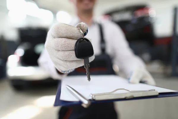 Empleado de servicio de coche tiene llaves en la mano y portapapeles — Foto de Stock