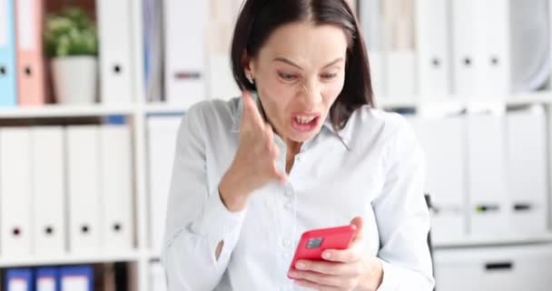 Femme en colère regardant l'écran de téléphone mobile et la tête d'accrochage film 4k ralenti — Video