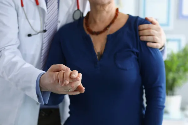 Trabajadora médica en uniforme ayuda a anciana a caminar cogida de la mano — Foto de Stock