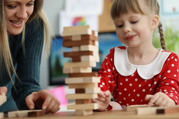 Daughter and mother spend time together playing funny wooden blocks game — Stock Photo, Image