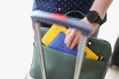 Çantanın uçuş belgelerini çıkaran adam.