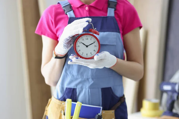 Vrouwelijke werknemer in uniform met rode klok herinnering om werk op tijd af te maken — Stockfoto