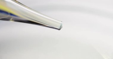Şeffaf temiz damlacıklar pipette yavaş çekim 4K filminden damlıyor.