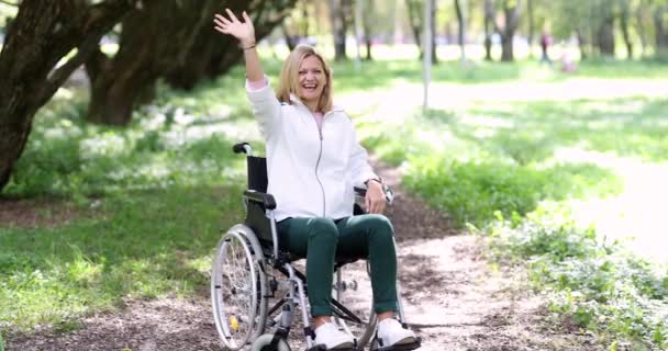 Jovem mulher em cadeira de rodas feliz abraços homem no parque câmera lenta filme 4k — Vídeo de Stock