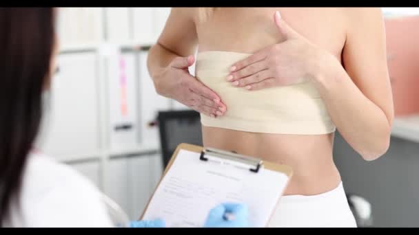 Paciente femenina en una cita con un mamólogo con dolor en el pecho película en cámara lenta 4k — Vídeos de Stock