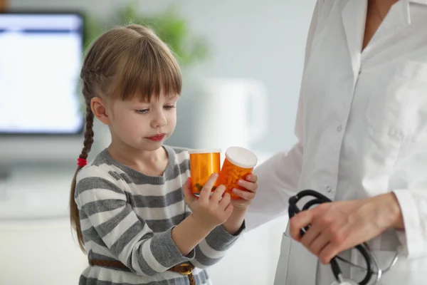 Gyermek játszik palack tele gyógyszerrel, miközben az orvosok kinevezése — Stock Fotó