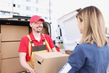 Kurye ve alıcı kadın ödeme ve paketle ticaret yapmak için buluşuyor.