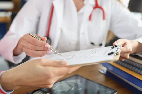 Kvinnlig läkare och patient underteckna medicinska kontrakt — Stockfoto