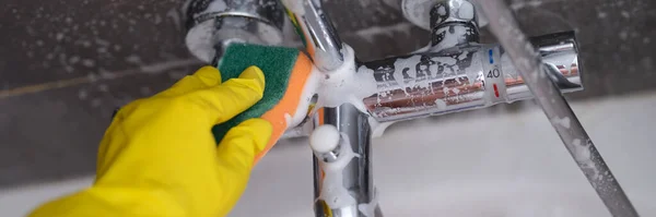 Huisvrouw in rubber handschoen wassen kraan in badkamer met spons closeup — Stockfoto