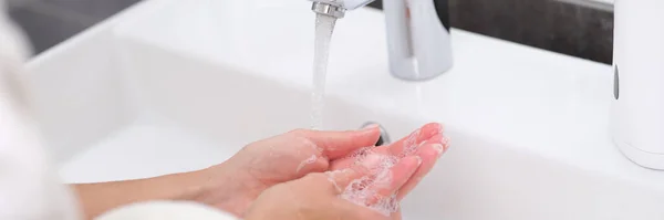 Frau wäscht sich im Badezimmer die Hände unter Wasser aus dem Wasserhahn — Stockfoto