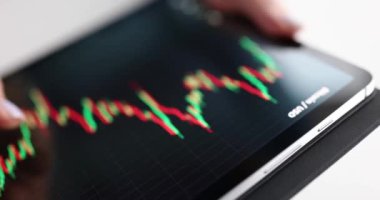 Kadın, dijital tablet üzerindeki kripto para birimlerinin grafiğini inceliyor. Yakın çekim 4k film ağır çekim.