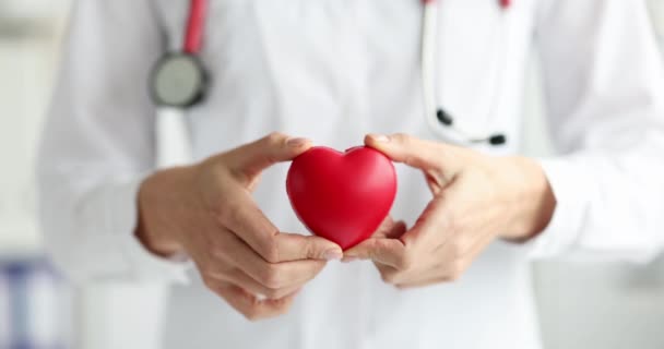 Doctor holding toy red heart in his hand 4k movie slow motion — Stock Video