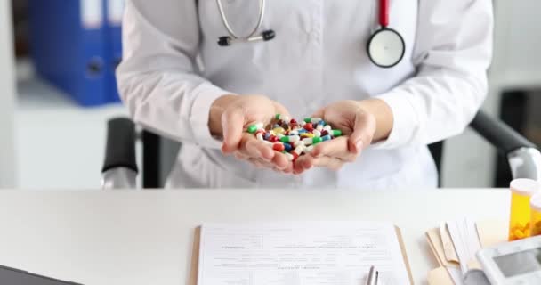 Médecin femme tenant poignée de capsules multicolores avec des médicaments à la clinique 4k film ralenti — Video