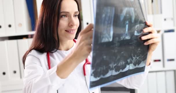 Mujer médico mirando la radiografía de la columna vertebral en la clínica 4k película cámara lenta — Vídeos de Stock
