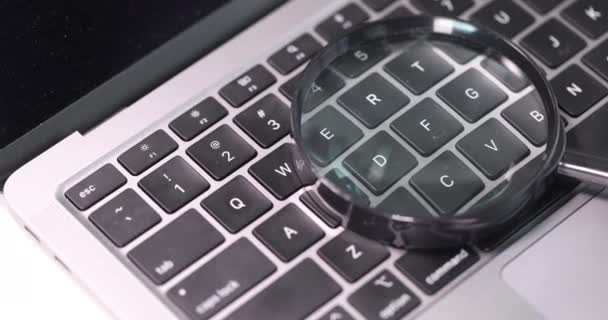 Lupa se encuentra en el teclado de la computadora de cámara lenta 4k película — Vídeo de stock