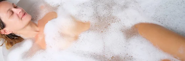 Jovem mulher nua deitada em banho de espuma — Fotografia de Stock