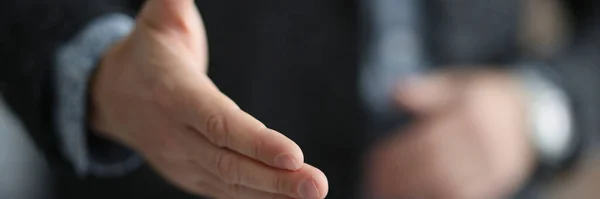 Empresário de terno esticando a mão para aperto de mão com o parceiro close-up — Fotografia de Stock