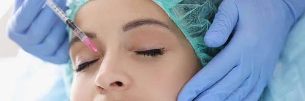 Врач-косметолог делает инъекции в носовую область пациентки в клинике — стоковое фото