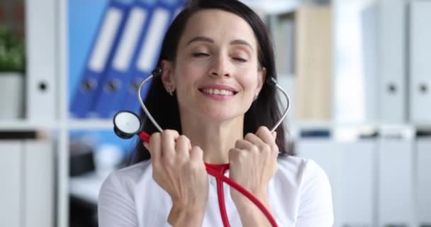 Женщина-врач вставляет стетоскоп в уши в клинике 4К фильм замедленной съемки — стоковое видео
