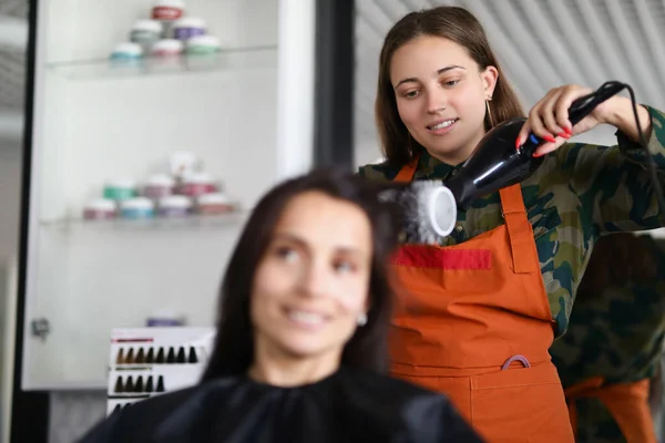 Lächelnder Friseur mit Haartrockner für die Behandlung mit Haaren und kreativ sein — Stockfoto