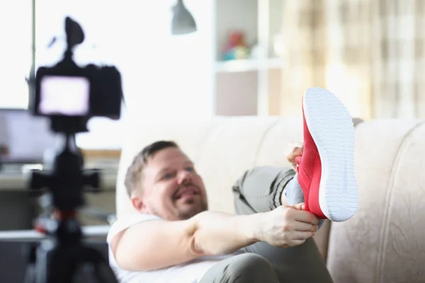 Idade média masculino colocando na moda tênis vermelho mostrando na câmera — Fotografia de Stock