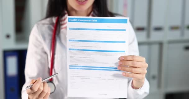 Mujer sosteniendo el documento de reclamo de seguro de salud en sus manos película 4k cámara lenta — Vídeo de stock