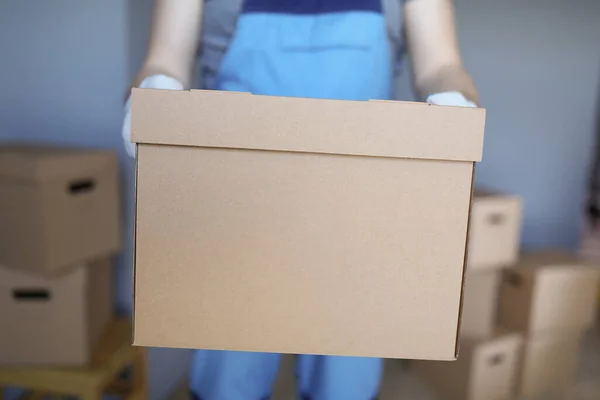 Рабочий загружает картонные коробки с вещами владельцев в новую квартиру — стоковое фото