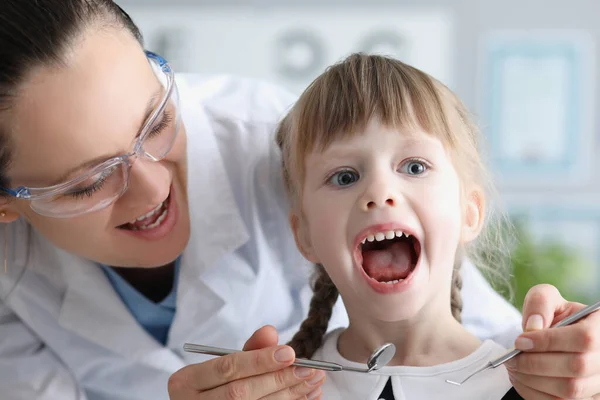 Χαριτωμένο παιδί επισκέπτονται οικογενειακό γιατρό και ανοιχτό στόμα παιδίατρος με έλεγχο εργαλείο πληγώνει το λαιμό — Φωτογραφία Αρχείου