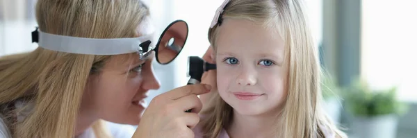 Otorrinolaringologista olha para meninas pequenas orelhas com otoscópio close-up — Fotografia de Stock