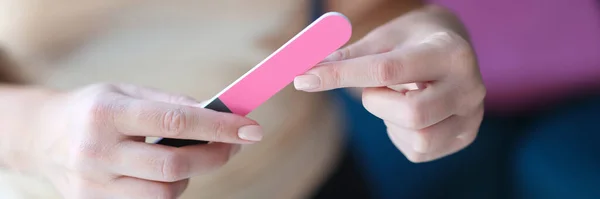Frau feilt Fingernägel mit rosa Nagelfeile Nahaufnahme — Stockfoto