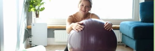 집에 양탄자에 커다란 체조 공을 단 행복 한 젊은 여자의 모습 — 스톡 사진
