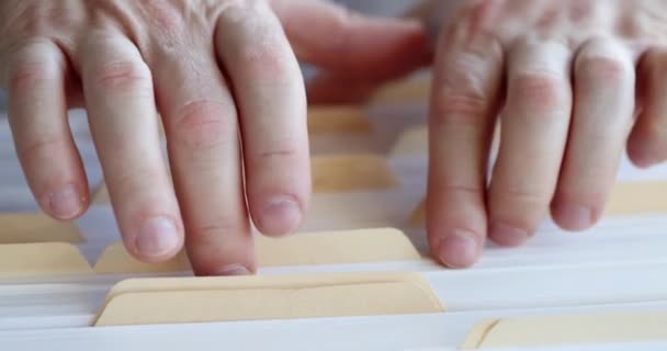 Mannelijke handen sorteren door mappen met documenten in archiefkast — Stockvideo
