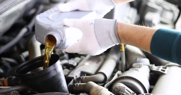 Automotive locksmith pouring engine oil into car engine — Stock Video