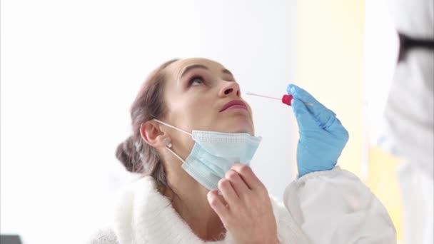 Doutor em terno protetor leva material biológico do nariz para análise — Vídeo de Stock