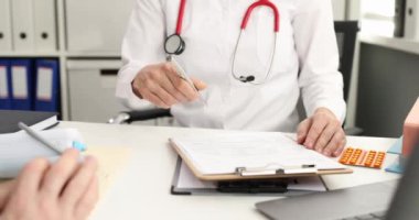 Doktor reçete yazıyor ve hastaya haplar veriyor. Yakın çekim 4K film yavaş çekim.