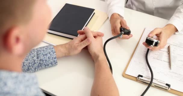 Médico medir a pressão arterial para o paciente na clínica filme 4k câmera lenta — Vídeo de Stock