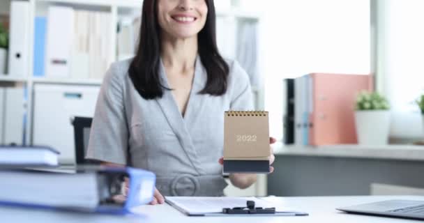 Mulher colocando calendário de mesa para 2022 na mesa 4k filme câmera lenta — Vídeo de Stock