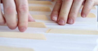 İş belgeleriyle klasörleri sıralayan erkek eller