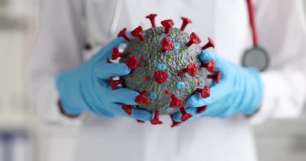 Doktor Coronavirus molekülünün yapay modelini tutuyor. Yakın çekim 4k film ağır çekim. — Stok video