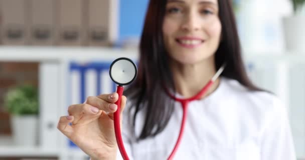 Mujer médico sosteniendo estetoscopio rojo en la clínica de primer plano 4k película cámara lenta — Vídeo de stock