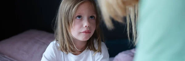 Mutter spricht mit traurigem kleinen Mädchen im Bett — Stockfoto