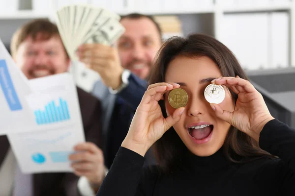 Mujer alegre muestra monedas bitcoins, primer plano, borrosa — Foto de Stock