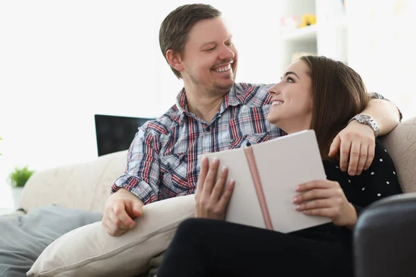 Medelålders far och dotter läser bok tillsammans sitter på soffan hemma — Stockfoto